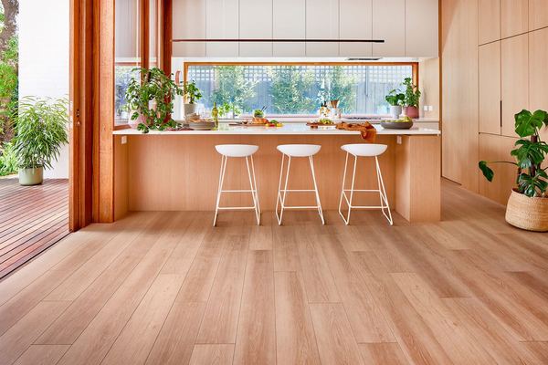 Kitchen with a timber bench and stools on a warm timber-look floor