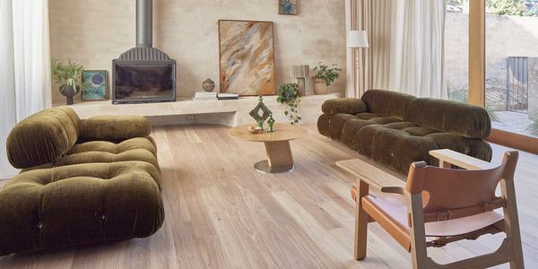 Living room with green sofas on wide engineered timber boards